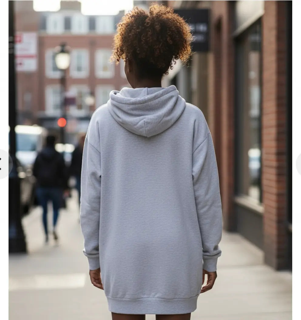 Back view of a person wearing a grey Nova Hoodie Dress on a city street.